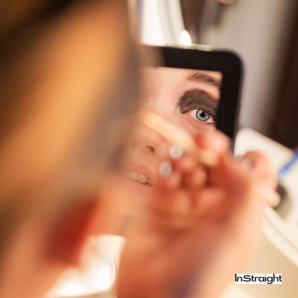 a woman applying heavy makeup